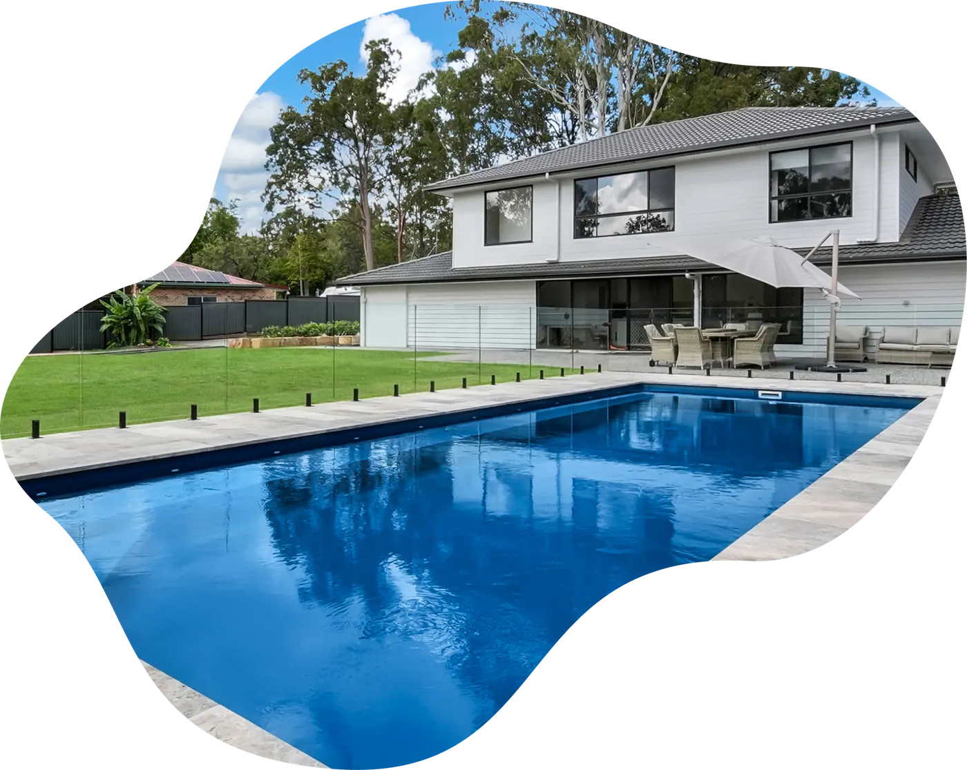 Blue fibreglass pool beside a two-storey home